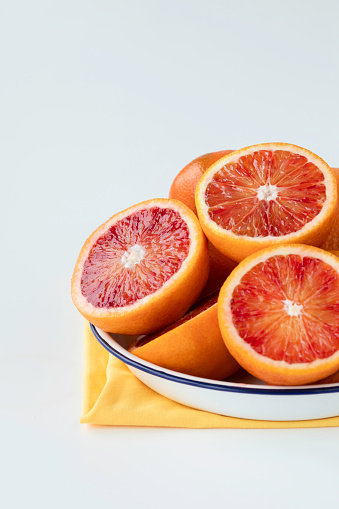 Abundance of blood orange slices on white background
