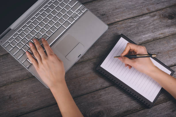 istock a young woman writes a text message on laptop keyboard with blank empty screen, rest homes, on wooden background 1456874217