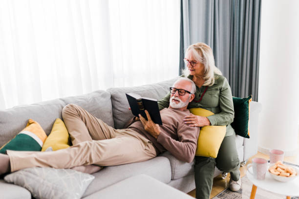 istock Senior couple reading book and resting at home 1456874297