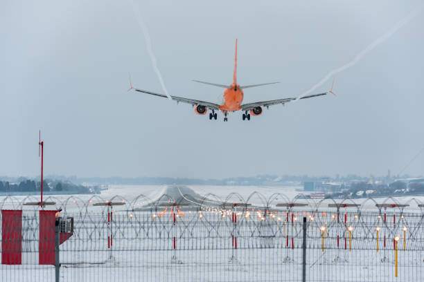 The plane with landing lights on and released chassis prepare for landing. Rear view