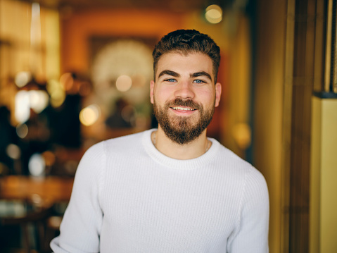 A video portrait of a man standing in a restaurant.