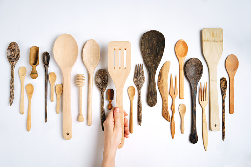 Various wooden spoons and spatulas on white background