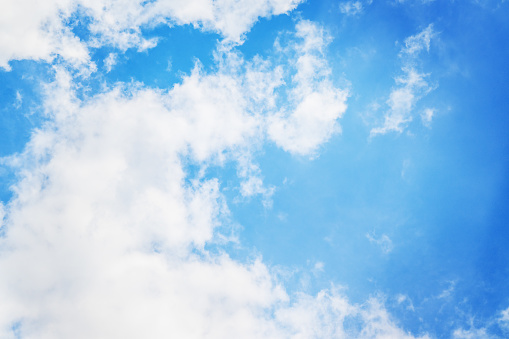 Peaceful blue sky background with light clouds.