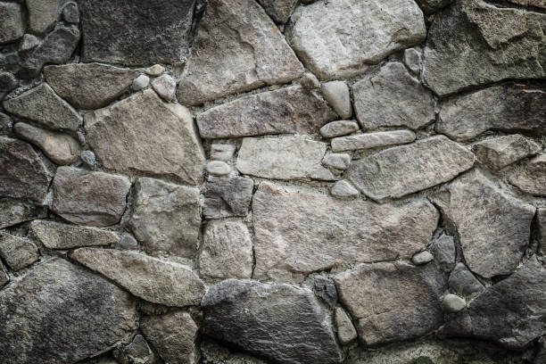 istock Black stones and rocks of different shape, gray background 1456888035