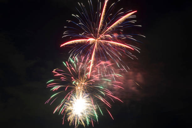 vista aérea de fogos de artifício brilhantes explodindo com luzes coloridas contra o céu escuro da noite no feriado do dia da independência dos eua - exploding celebration multi colored colors - fotografias e filmes do acervo