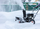 Winter, blizzard. Cleaning the area with a snow blower.