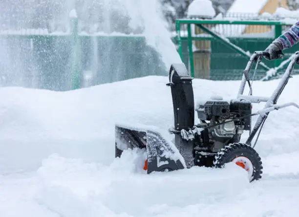 Winter, blizzard. Cleaning the area with a snow blower