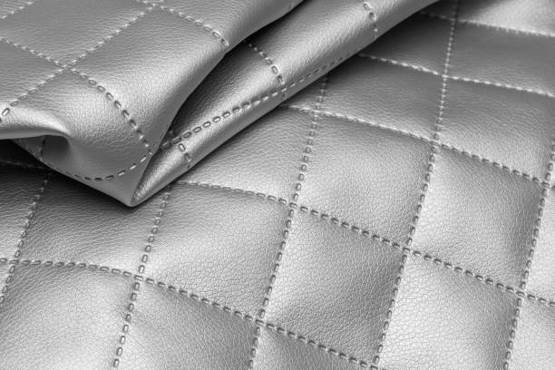 Quilted fabric sample with silver texture. Metallic leather background Quilted fabric sample with silver texture. Metallic leather background. fake leather stock pictures, royalty-free photos & images