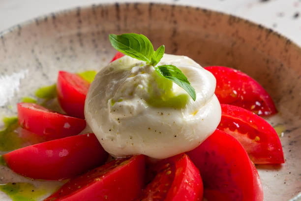 salada com queijo buratta, manjericão e tomates na tigela na mesa de mármore branco extremo macro close up - buratta - fotografias e filmes do acervo