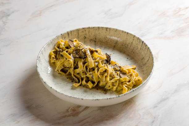 tagliatelli pasta with black truffle on marble table