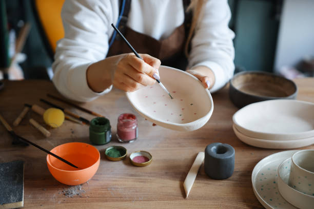 istock Skillful young woman in apron painting pottery at workshop 1456890852