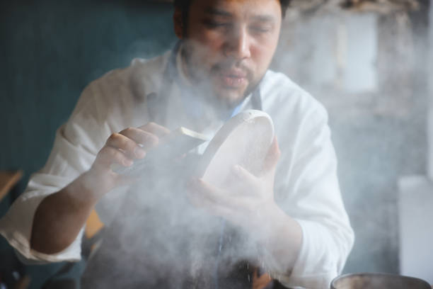 istock Skillful young man in apron painting pottery at workshop 1456890935