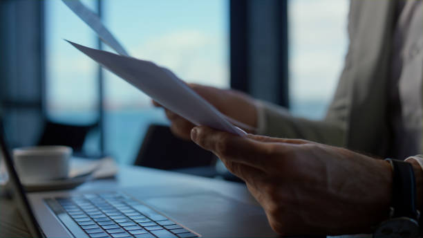 istock Businessman hands holding papers in marine view office. Director with reports 1456893544