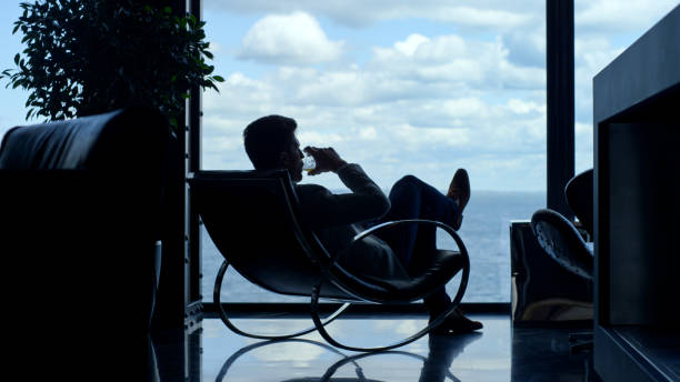 silhueta homem desfrutando de conhaque vida de férias em vista para o mar. empresário relaxando - people traveling abstract glass men - fotografias e filmes do acervo