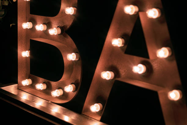 istock B A R letters lighted by spotlights on a dark black background 1456902736