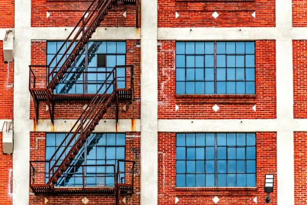 A full frame view of the rusted steel fire escape on the exterior of an old abandoned factory located in downtown Houston, Texas.