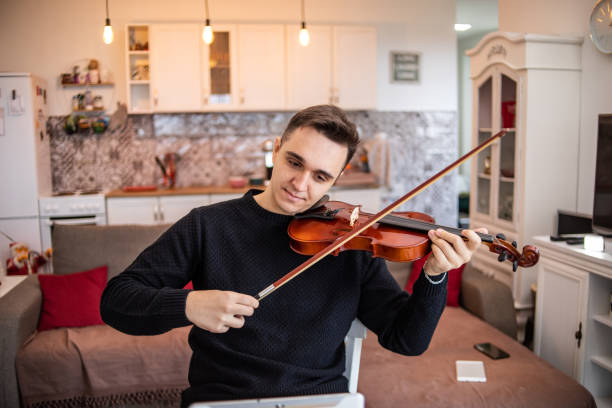 istock A young man plays the violin, learns the basics of playing a stringed instrument 1456905464