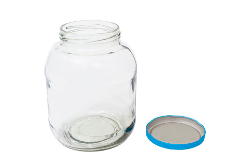 An empty pickle jar shot from slightly above with its lid to the side.  Both are isolated on white with copy space.
