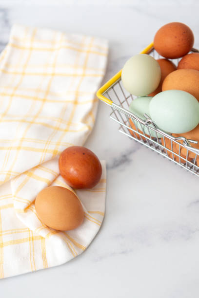 istock Wire Basket of Fresh Brown and Blue Chicken Eggs on White Counter 1456907280