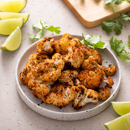Spicy roasted cauliflower served with lime and chopped cilantro