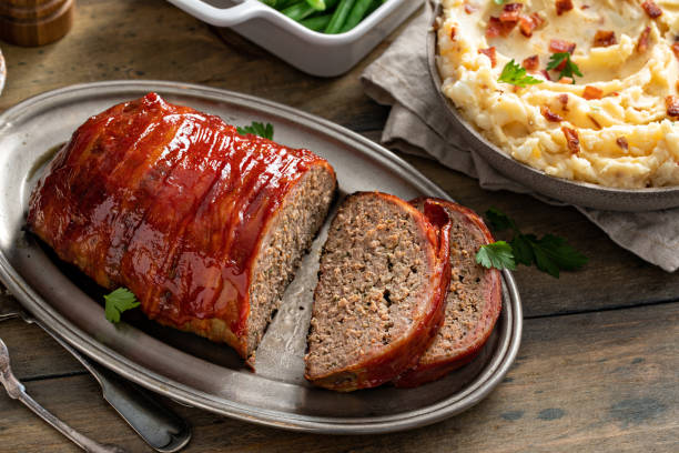 Bacon wrapped meatloaf sliced on a serving plate Bacon wrapped meatloaf sliced on a serving plate for dinner cooked bacon slice stock pictures, royalty-free photos & images