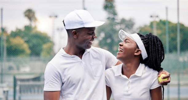 tennis, coppia felice e nera ridono dopo la vittoria dell'allenamento e amore estivo insieme per il fitness. esercizio fisico, salute e allenamento sportivo insieme a un sorriso su un campo da tennis dopo una partita con felicità - tennis court love victory foto e immagini stock