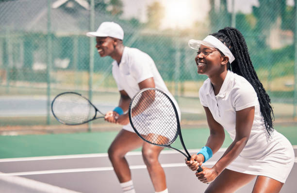 tennis, sport und wettkampf mit einer schwarzen frau und einem doppelpartner, die gemeinsam ein spiel auf einem platz im freien spielen. fitness, team und bewegung mit einem tennisspieler und einer tennisspielerin an einem sportort - doubles stock-fotos und bilder