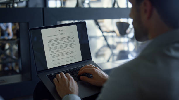 istock Businessman working laptop reading contract in office. Expert using touchpad 1456910649
