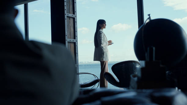 Businesswoman watching sea view big window. Thoughtful leader boss relaxing