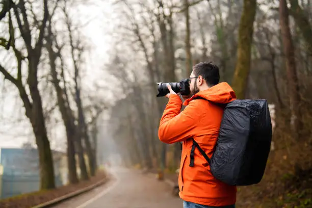 Photo of Traveller taking photograph in woodland with a mirrorless camera