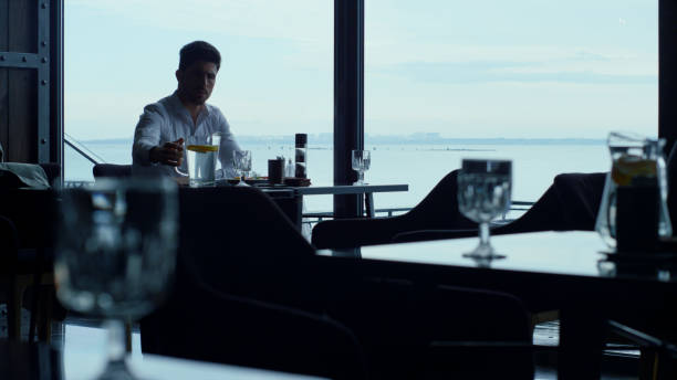 istock Intelligent man silhouette enjoying scenic seascape resting panoramic window bar 1456918336