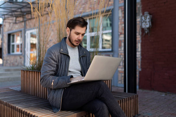 istock man working on laptop outside online 1456922734