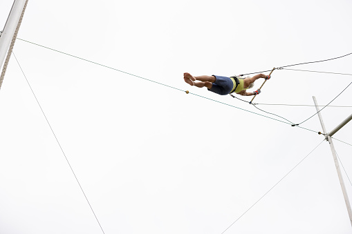 Mature female trapeze artist flying in the sky