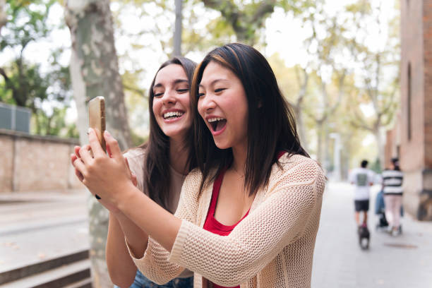 istock women having fun looking content on at phone 1456922854