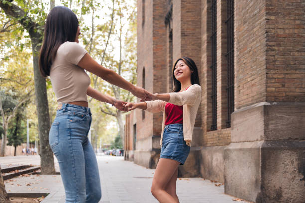 istock women have a good time spinning holding hands 1456922868