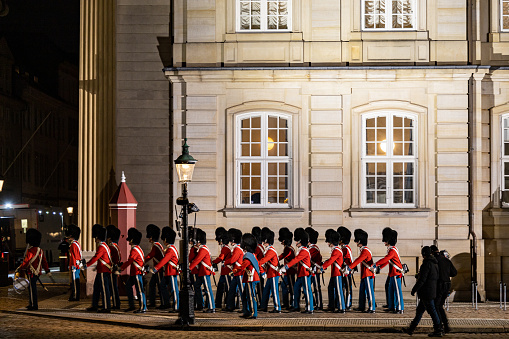 Unit of the Royal Life Guards marching in line and relieve the outgoing guard at the post. Changing of the Guard at Amalienborg palace in Copenhagen in Denmark