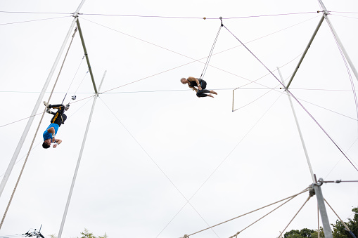 Two trapeze artists flying together