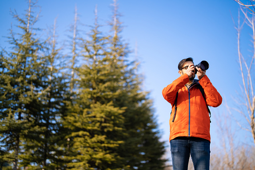 Close up of a man looking through binoculars, outdoors.