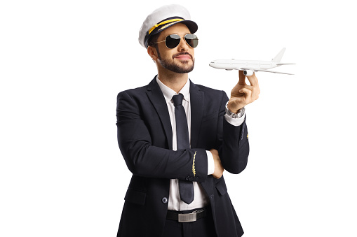 Pilot holding a small airplane model isolated on white background