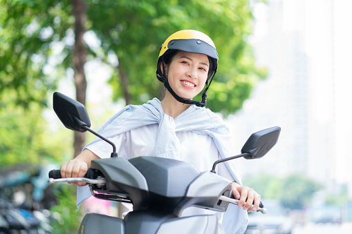 Photo of young Asian woman driving motorbike