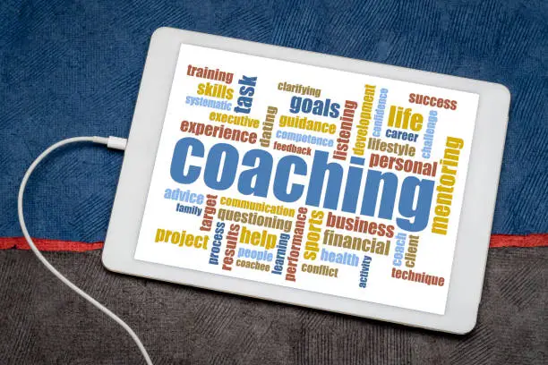 coaching - word cloud on a digital tablet against art paper landscape, business, career, lifestyle and sport concept