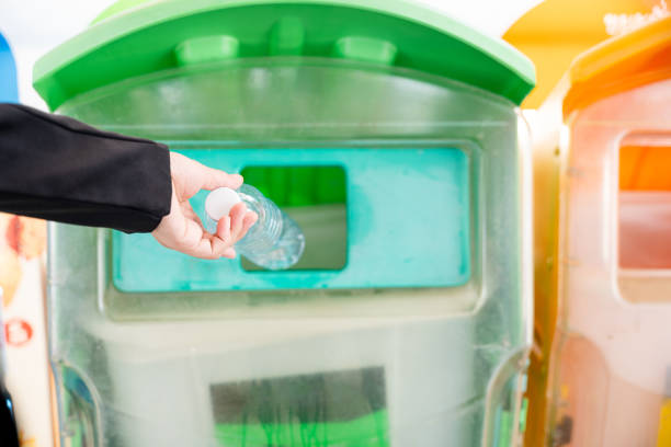 istock Business woman throwing empty plastic bottle water into recycle garbage trash 1456957751