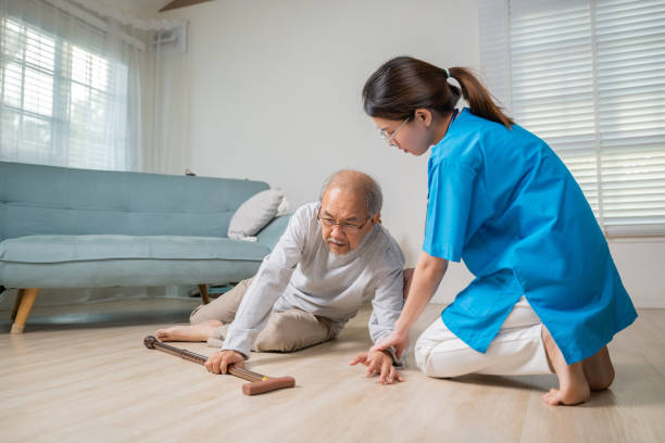 asiatischer älterer älterer mann, der auf den liegenden boden fällt und eine krankenschwester kam, um zu helfen - falling people tripping senior adult stock-fotos und bilder