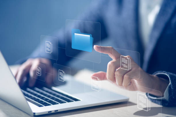 istock Document Management System DMS and Software for archiving searching and managing files online document database. Consultant information technology setup DMS working on computer 1456965549