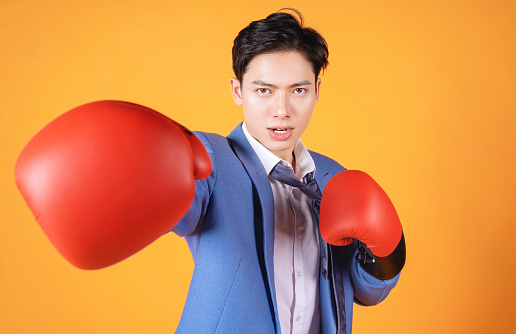 Image of young Asian anger businessman with boxing glove
