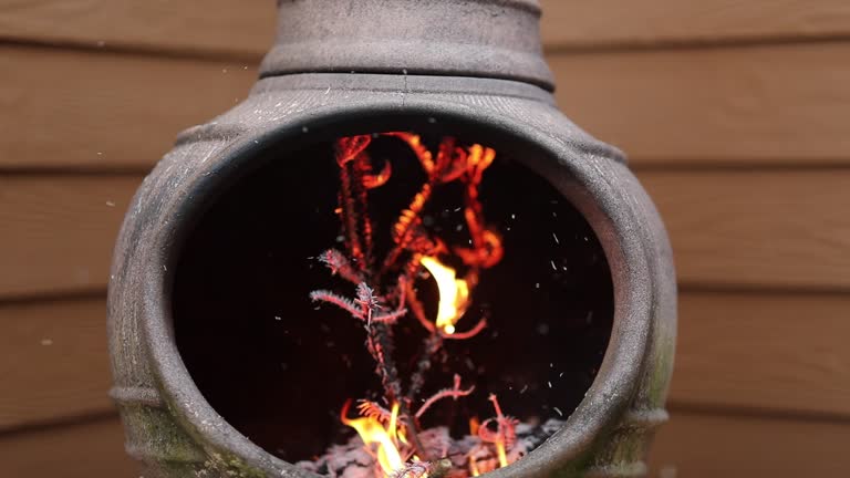 Rustic Chiminea Fire Pit Flaming with Cut Christmas Tree Pine Wood & Needles on a Cold Winter Day is Florida