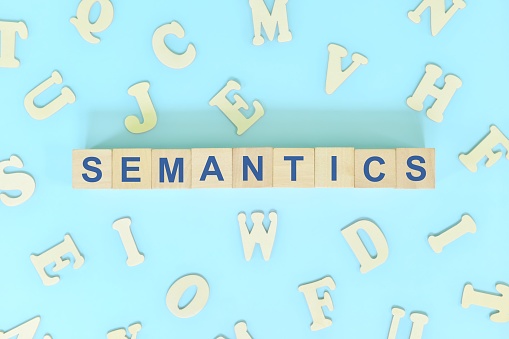 Estudiar semántica en concepto lingüístico. Bloques de madera palabra tipografía plana yacía en fondo azul. photo