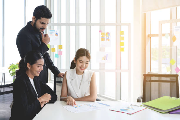 istock Business people group read some documents, making plans together in the office. Professional businesswomen and businessmen working with paper documents on the meeting table 1456975407