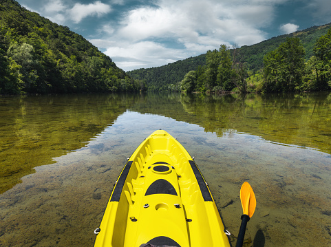 Yellow kayak in calm waters of Kolpa River.