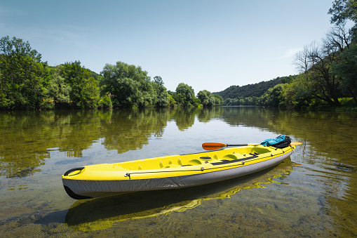 Yellow kayak in calm waters of Kolpa River.